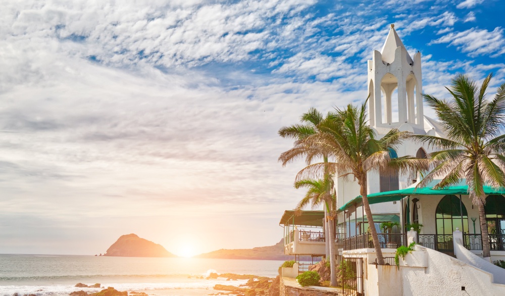 Vista de Mazatlán con mar, palmeras y arquitectura local al atardecer